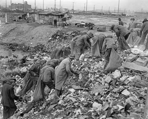 THEN: Unemployed men search for anything useful in land being reclaimed with city garbage used for fill on the tideflats. The date is March 6, 1937. The scene looks northwest from what was once near 7th Ave. S. and Forest Street, but is now inside the operations facilities for the Light Rail Division of Sound Transit. The Sears Department Store, now home of Starbucks Coffee Co., appears in the upper-left corner. Courtesy: The Post-Intelligencer Collection at the Museum of History and Industry.